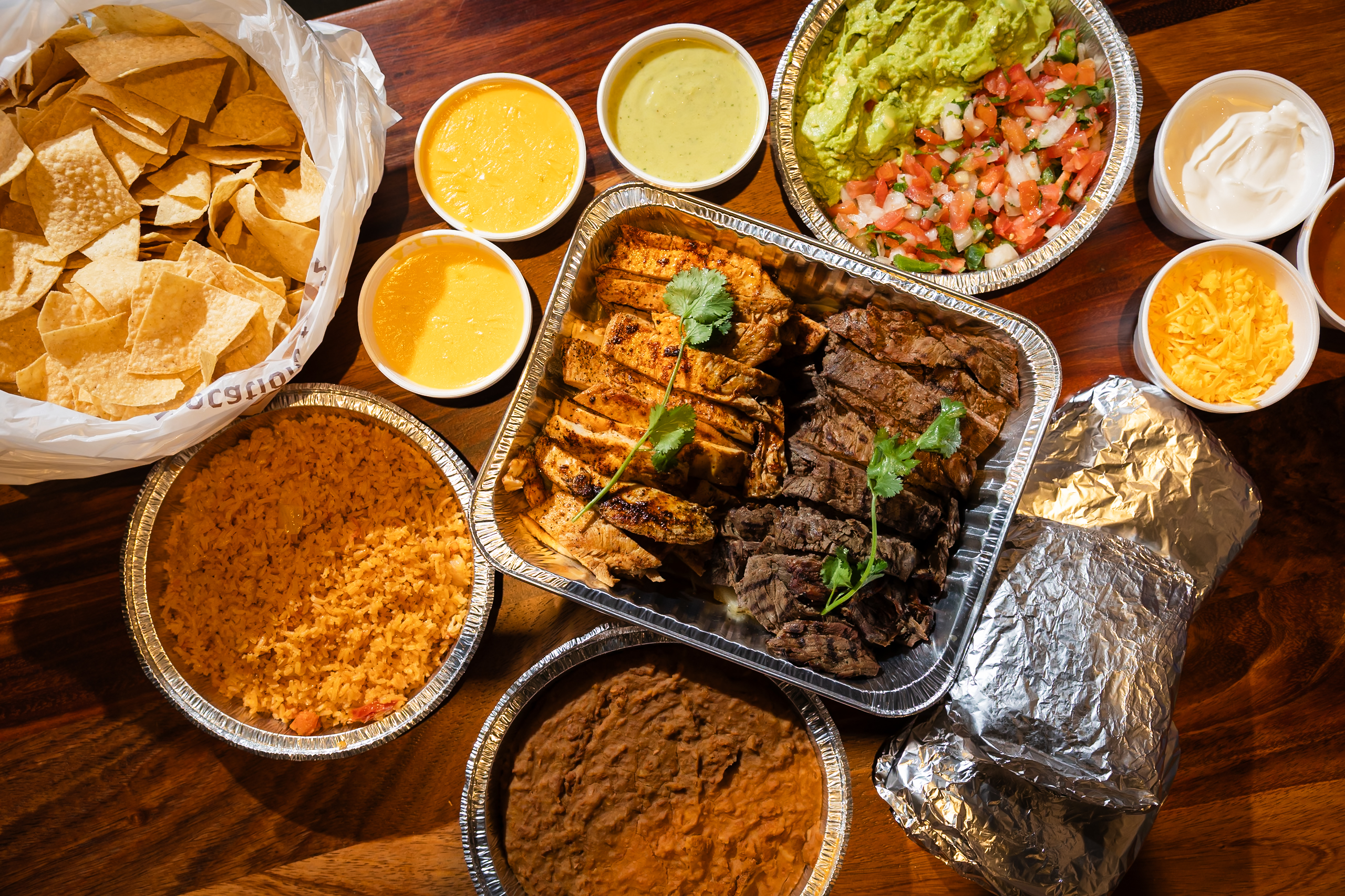 Overhead Grande Box spread with beef and chicken fajitas, rice, beans, chips and sides