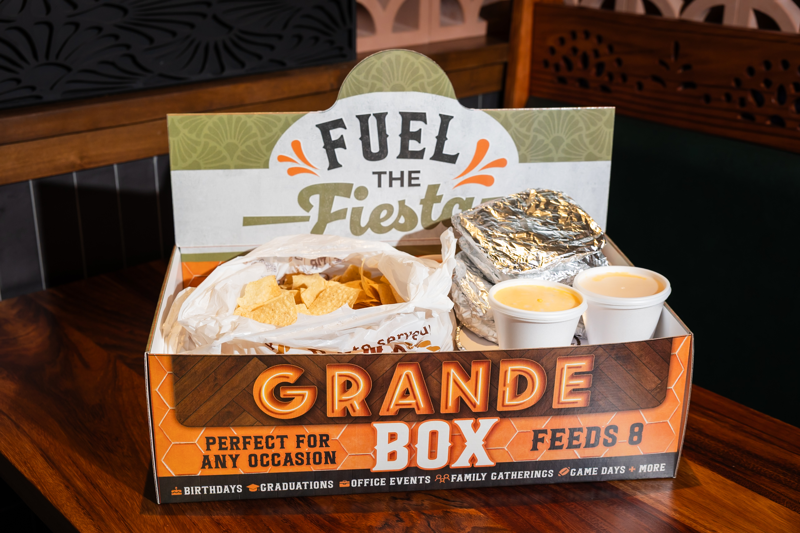 Open Mi Rancho Grande Box with chips, foil packs and sides beneath the Fuel the Fiesta lid