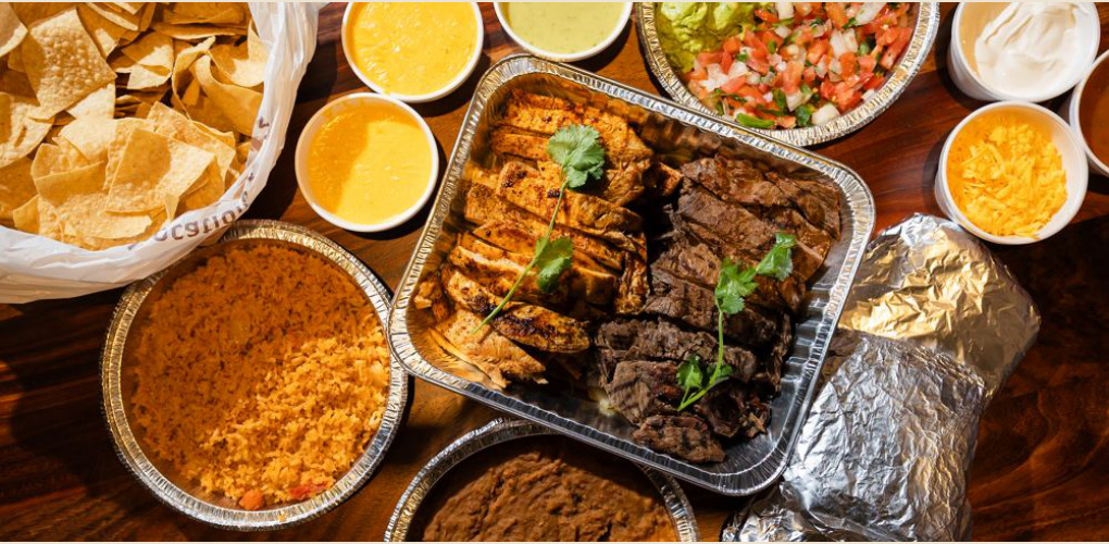 Mi Rancho fajita spread with beef and chicken fajitas, rice, beans, chips and sides